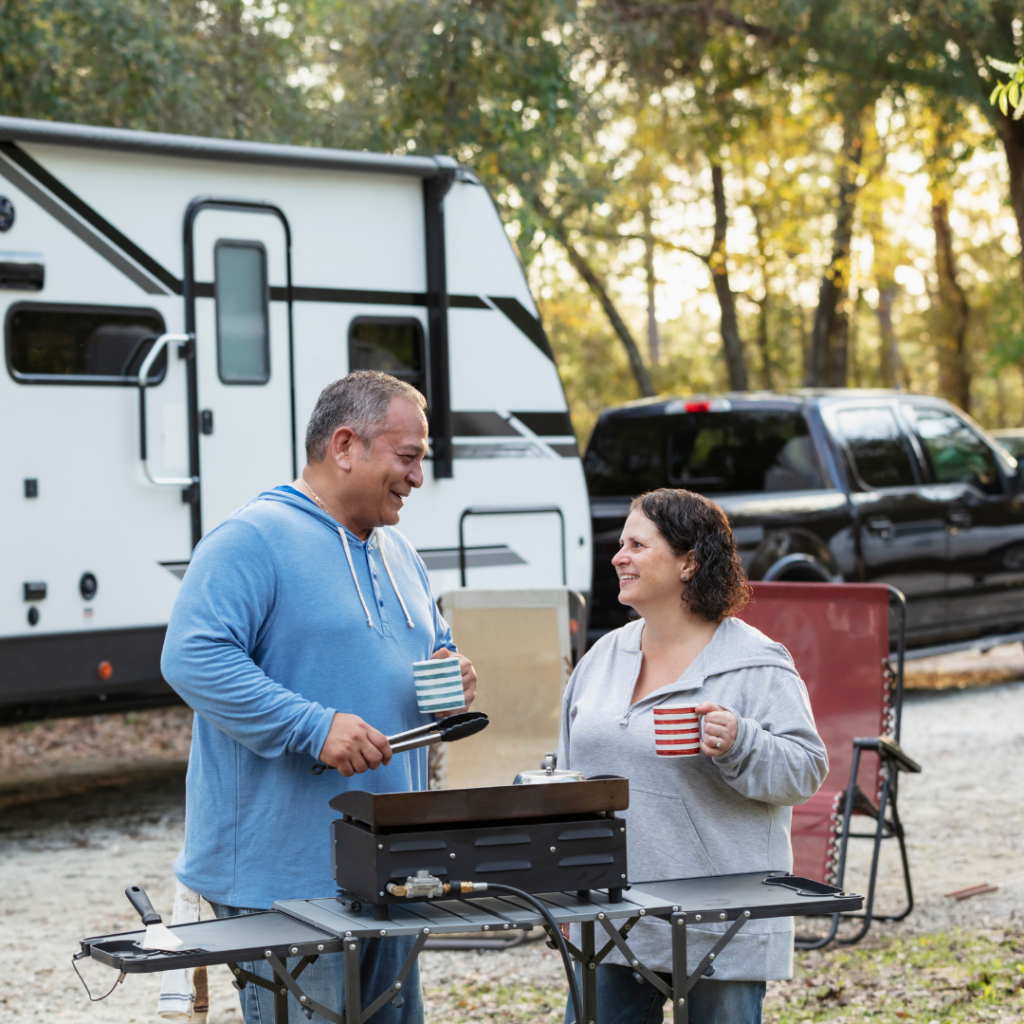 Two RVers grilling outdoors at campsite