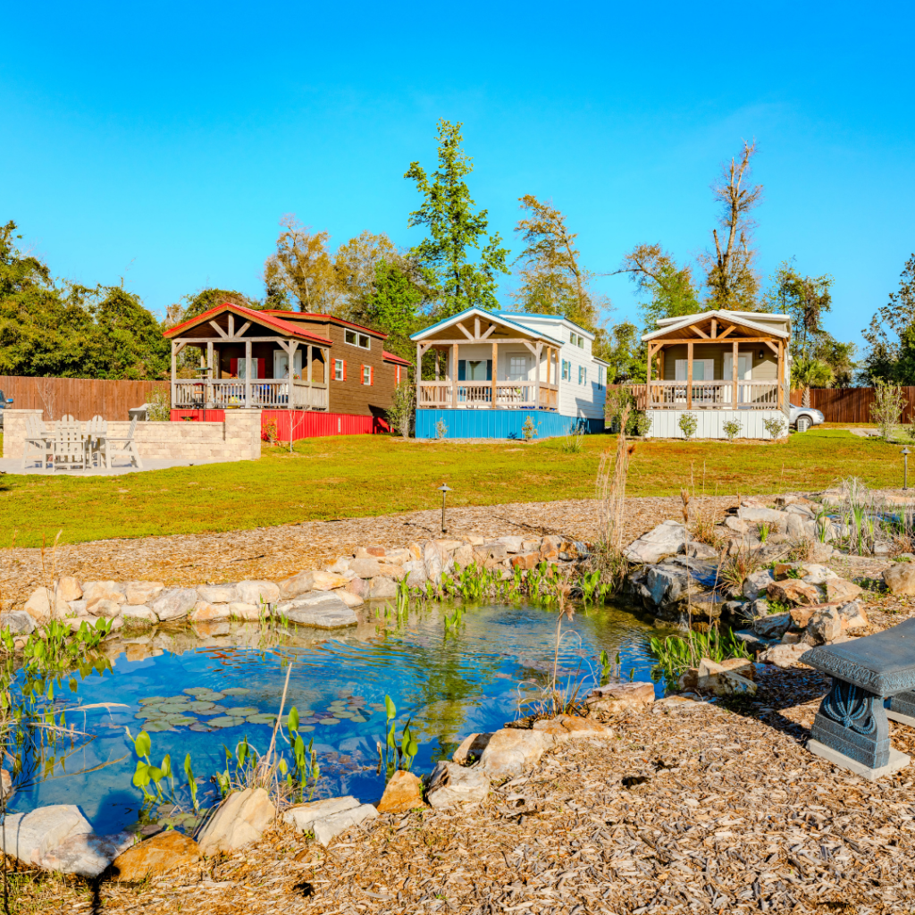 3 of Florida Caverns RV Resort's luxury cabins with a koi pond in front