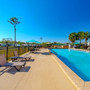 Outdoor pool at Florida Caverns RV Resort with lounging chairs