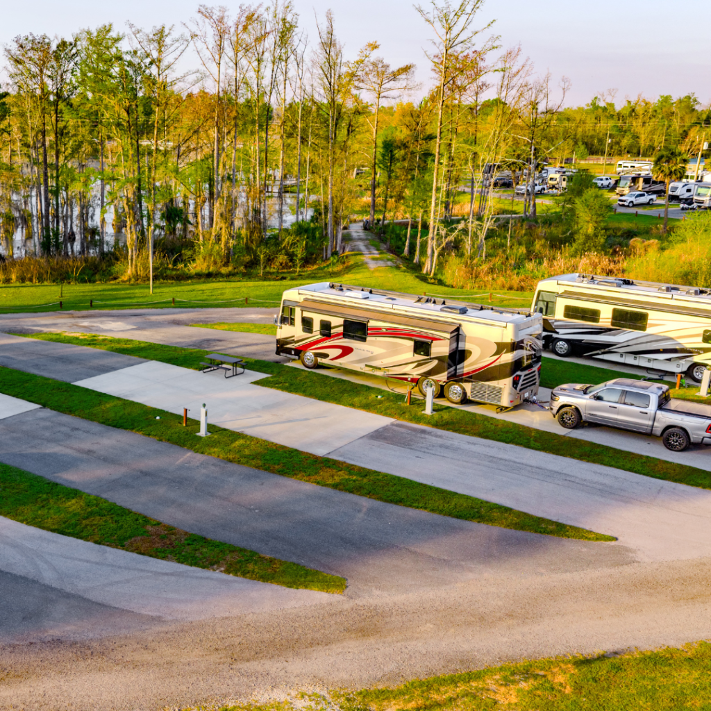 Front facing shot of the premium RV sites at Florida Caverns RV Resort. The RVs are facing away from the camera, overlooking the trees and Merritt's Mill Pond
